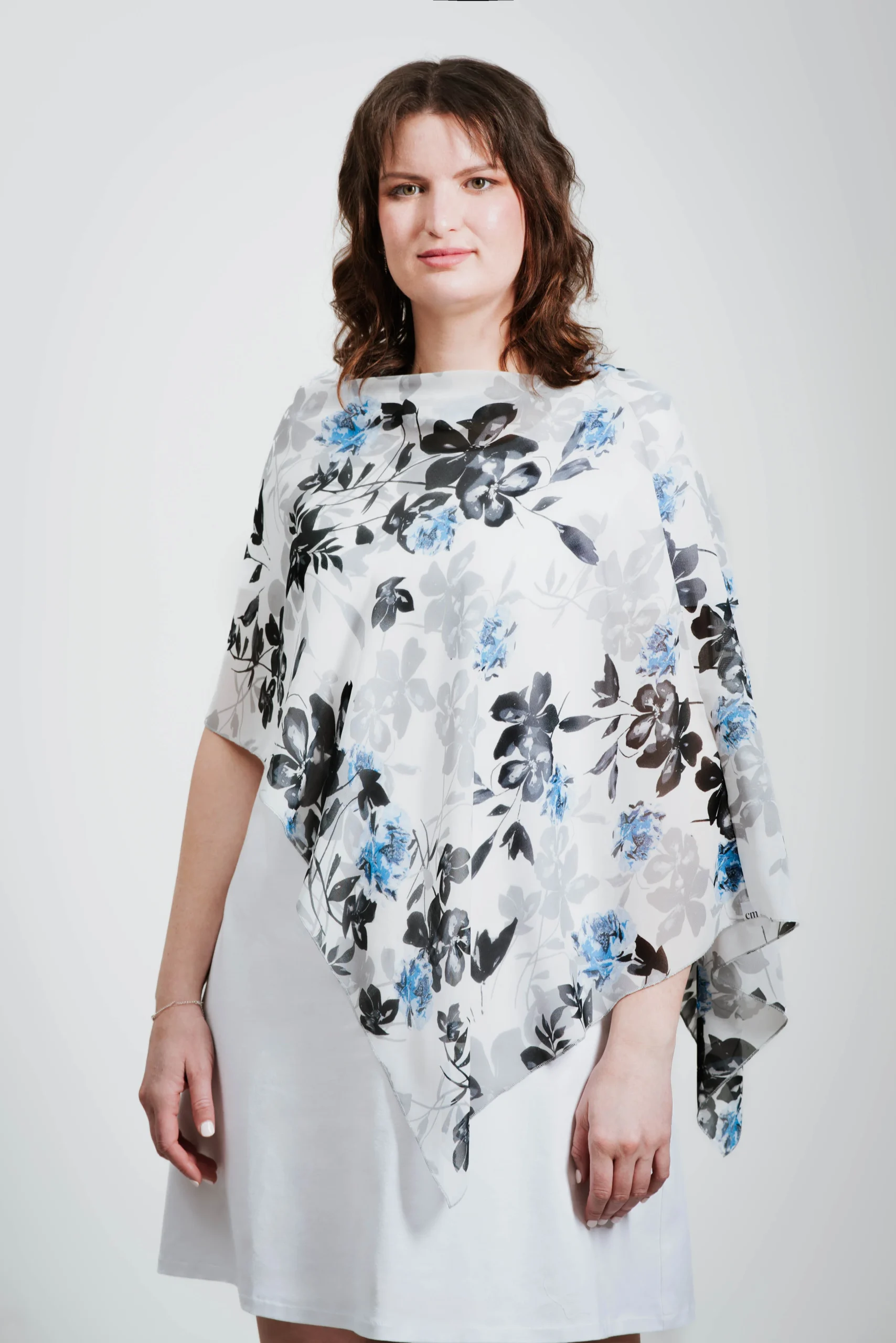Poncho court en voilage fleuri noir, gris et bleu sur fond blanc